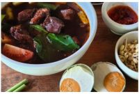 Rawon disajikan dengan telur asin dan juga tauge
