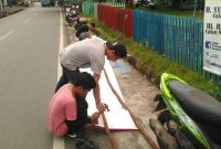 Jom Positif mengganti kayu penyangga Spanduk Paslon Pilkada (hms Jom Positif)