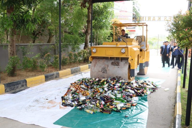 Ribuan Minuman Keras yang dimusnahkan menggunakan alat berat di lapangan Mapolres Karimun