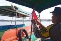 Anggota Polsek Tanjungpinang Kota memasangkan bendera merah putih di salah satu transportasi laut, Jumat (1/8/2025) foto: istimewa 