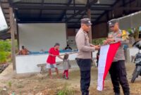 Personel Polsek Singkep Barat memasang bendera merah putih, Selasa (5/8/2025) foto: Herdoni/Polsek Singkep Barat
